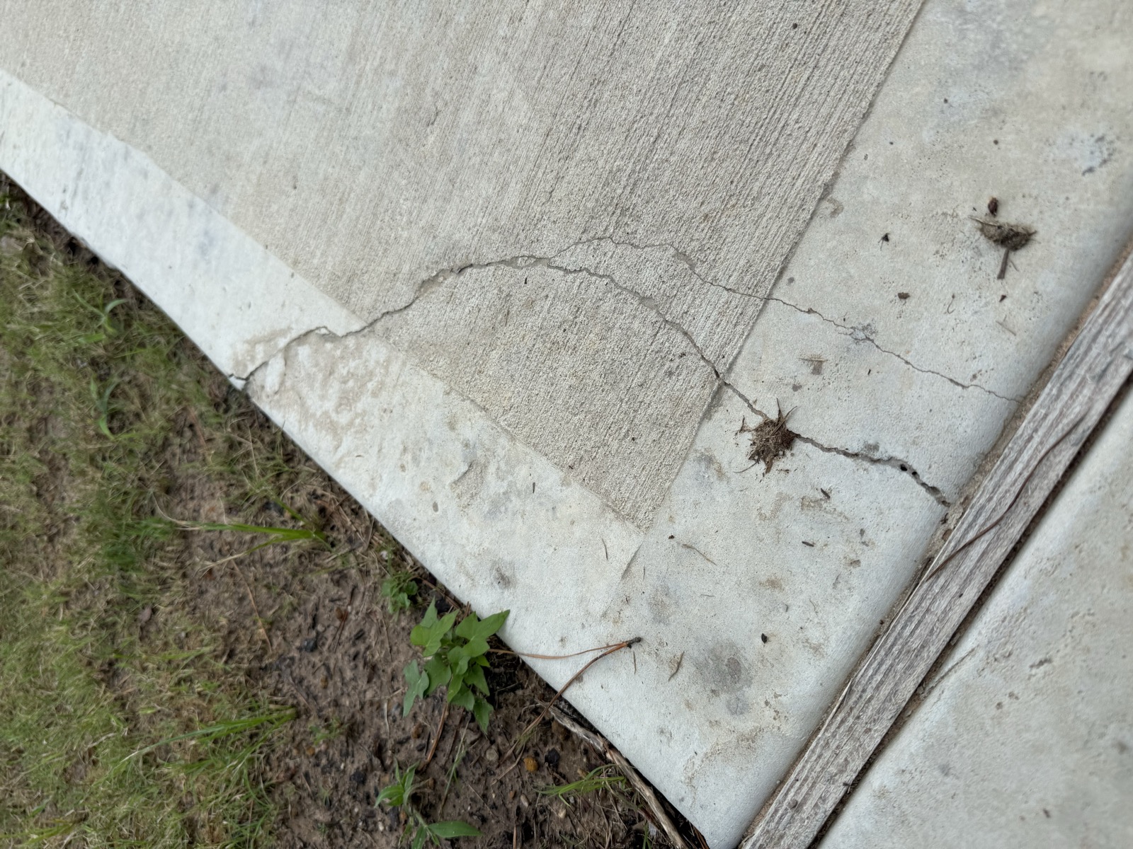 Cracked and broken corner of a driveway pad