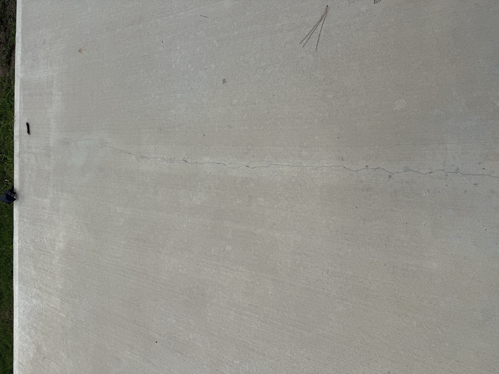 Full-slab crack running end to end across the driveway