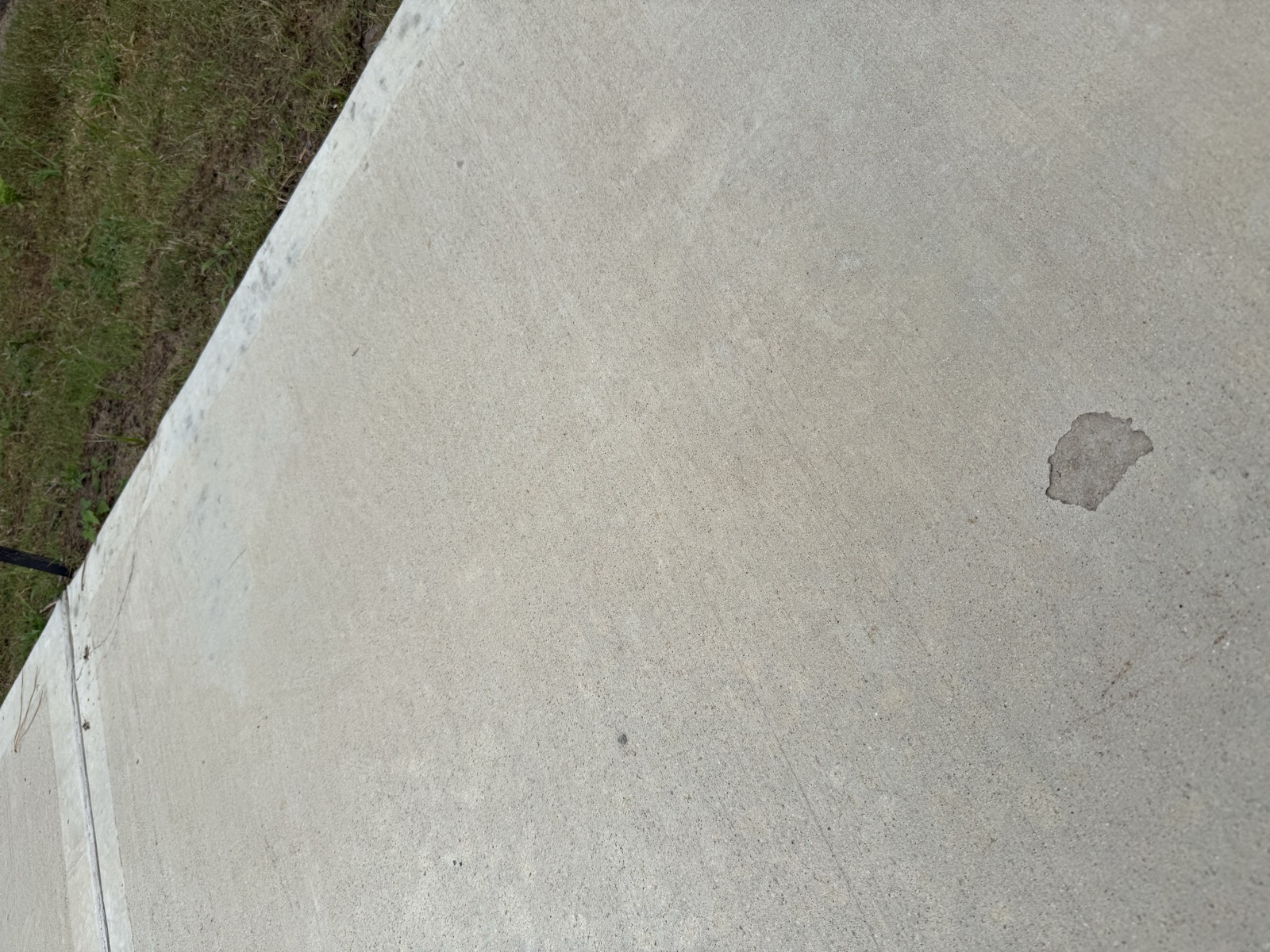 Surface spall / pop-out in the driveway concrete