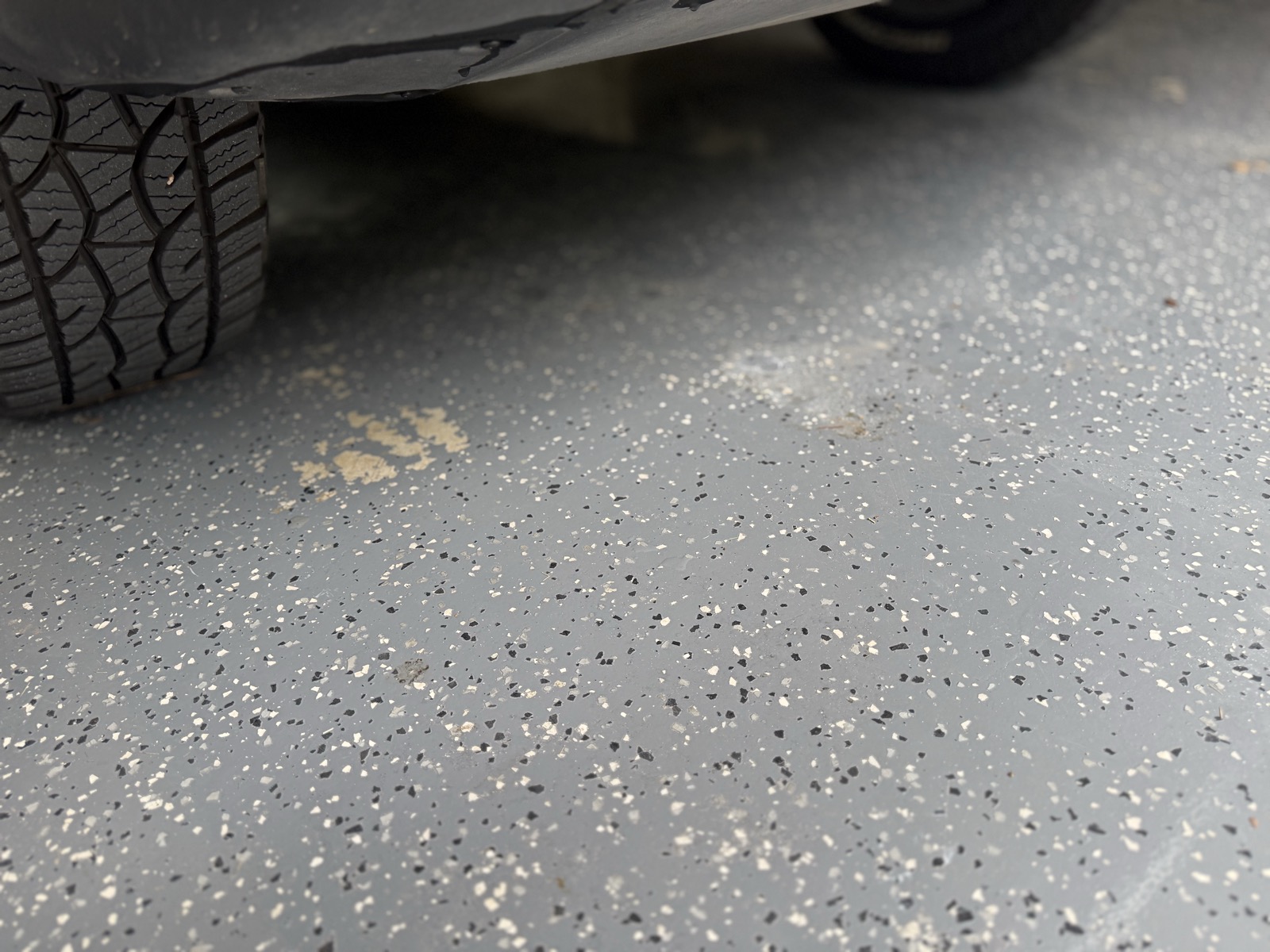 Epoxy garage floor peeling under a vehicle tire